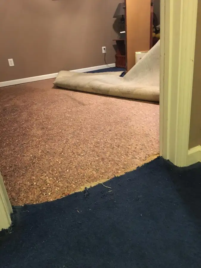 Carpet pad removal revealing water damage during Water Mitigation Services in Enumclaw